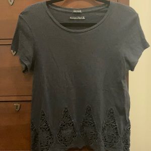 A blue t shirt with lace detail.